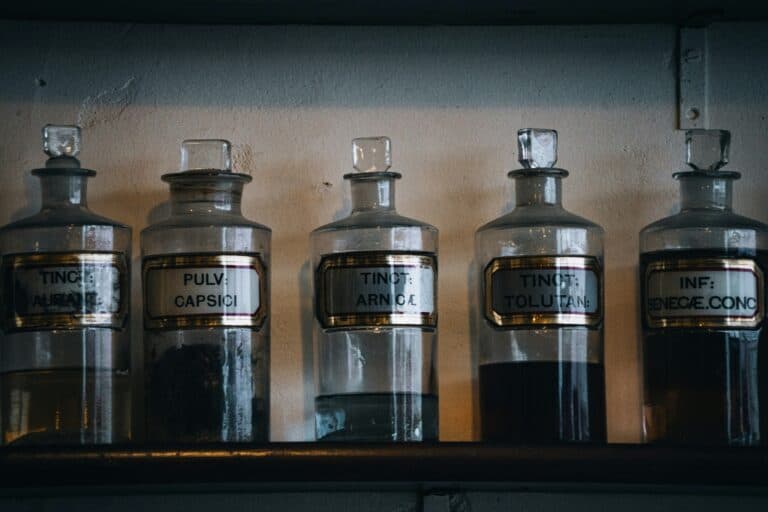 Medication bottles with Latin labels on a shelf in a medical setting.